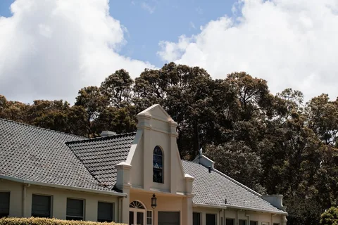 Façade d’une maison entourée de végétation pour illustrer le rôle du bâtiment dans le confort